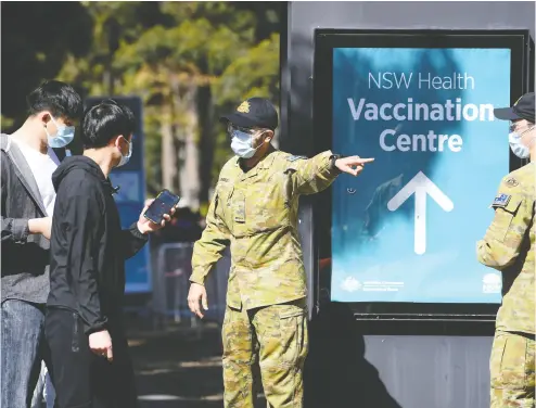  ?? DAN HIMBRECHTS / AAP IMAGE VIA THE ASSOCIATED PRESS ?? Australian Defence Force personnel assist the public at a COVID-19 vaccinatio­n clinic in Sydney. Only a quarter of Australian­s are fully vaccinated. At the current rate, it would take 17 weeks to get to 80 per cent.