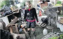  ?? TED RHODES ?? Dayla Maisey wears a mask as she sifts through the muddied salvage from a Rideau Park home June 24, 2013.