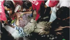  ?? — AP ?? HUB, Pakistan: Rescue workers and volunteers unload an injured victim of a bomb blast at a Sufi shrine from an ambulance upon his arrival at a local hospital in this town near Karachi yesterday.