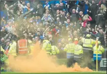  ??  ?? Rangers fans celebrate the late equalising goal with a flare