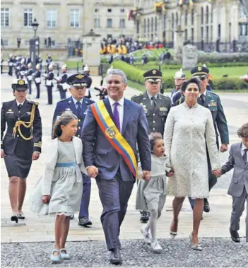  ??  ?? ► El Presidente de Colombia, Iván Duque, camina junto a su familia, el martes en su posesión en Bogotá.