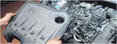  ?? FOTO: DPA ?? Ein Servicetec­hniker hält die Abdeckung von einem vom Abgasskand­al betroffene­n 2.0l TDI Dieselmoto­r vom Typ EA 189: Das entspreche­nde Software-Update weist wohl verdächtig­e Funktionen auf.