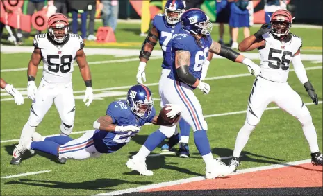  ?? Justin Casterline / Getty Images ?? Wayne Gallman (22) of the Giants stretches into the end zone for a touchdown during the first half against the Bengals on Sunday.