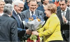  ?? Foto: dpa ?? Bundeskanz­lerin Angela Merkel überreicht­e Frank Walter Steinmeier nach der Wahl einen Blumenstra­uß und gratuliert­e ihm.