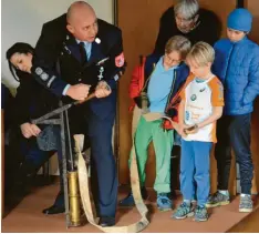  ??  ?? Rudolf Eser (links) zeigte den jüngsten Interessie­rten, wie das Wasser mit der Hand gepumpt wurde.