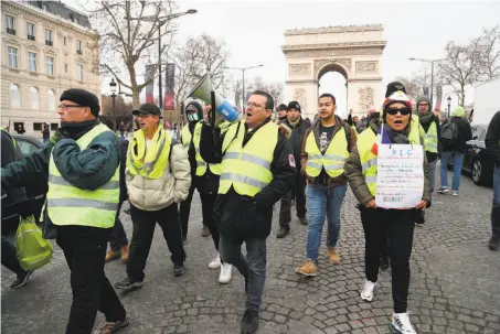  ?? Zakaria Abdelkafi / AFP / Getty Images ?? Protesters march near the Arc de Triomphe in Paris. Police said the number of protesters in the city has fallen in recent days.