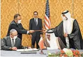  ?? RONEN ZVULUN/GETTY-AFP ?? Israel’s Meir Ben-Shabbat, left, and Bahrain’s Abdullatif al-Zayani sign the deal in Manama. Treasury Secretary Steven Mnuchin, back, attended Sunday’s ceremony.