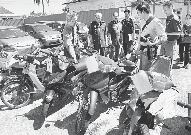  ?? — Gambar Bernama ?? LELONG: Mohd Zawawi (kiri) melihat motosikal yang dilelong dalam lelongan awam membabitka­n 18 motosikal, tiga motokar dan dua lori dengan harga serendah RM50 di JPJ Negeri Perak di Ipoh semalam.