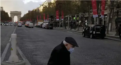  ?? FOTO: THIBAULT CAMUS/TT-AP ?? En äldre man med munskydd korsar paradgatan Champs-Élysées i Paris. Frankrike planerar att lätta på restriktio­nerna i tre steg.