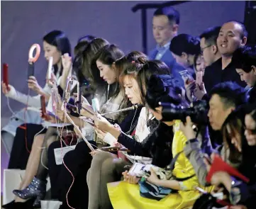  ??  ?? Girls prepare for their live broadcasts ahead of a show at China Fashion Week in Beijing yesterday. A 14-year-old Russian model who died after taking part in Shanghai Fashion Week earlier this month. — Reuters photo