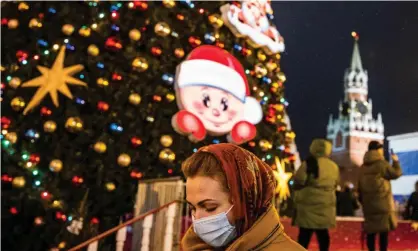  ?? Photograph: Dimitar Dilkoff/AFP/Getty Images ?? A woman walks past Christmas decoration­s in Red Square, Moscow.