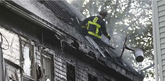  ?? NicoLaus czarnecki / HeraLd staFF FiLe ?? MUTUAL AID? A Hub firefighte­r works at the scene of a four-alarm blaze last month in Dorchester. A proposed fire cadet program has made its way to the governor’s desk, aiming to increase diversity in the department.