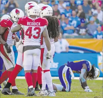  ?? Photograph­s by Robert Gauthier Los Angeles Times ?? RUNNING BACK Melvin Gordon of the Chargers waits for assistance, as Haason Reddick and other Arizona Cardinals gather nearby, after suffering a knee injury in the third quarter and leaving the game.