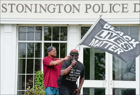  ?? SARAH GORDON/THE DAY ?? Wayne Rawls, nephew of Chrystal Caldwell, speaks as Al Mayo, a Gales Ferry resident, waves a Black Lives Matter flag behind him during a Peace & Justice for Chrystal Caldwell rally Sunday at the Stonington Police Department.