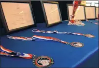  ?? JIM THOMPSON/JOURNAL ?? ABOVE: Abigail Wright spoons her mixture into pastry cups for the “Cup of Quiche” dish she created for the Future Chefs competitio­n. BELOW: Medals and awards presented at the competitio­n.