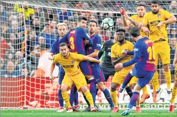  ??  ?? Lionel Messi (R) kicks the ball and scores against Atletico de Madrid during the Spanish league at the Camp Nou stadium in Barcelona.