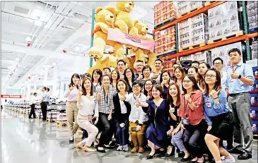  ?? AFP ?? Staff members pose for a group photo at a Costco store in Shanghai during a media day last week ahead of its official opening on Tuesday.