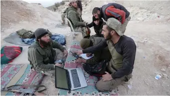  ?? (Khalil Ashawi/Reuters) ?? FREE SYRIAN ARMY fighters sit together in Afrin last week.