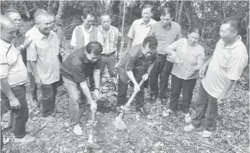  ??  ?? BEJADI: Alexander (tiga kanan) disempulan­g Penghulu Juin nyangkul tanah kelai bejadi pengawa sehari nya.