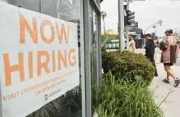  ?? MARIO TAMA/GETTY ?? A “Now Hiring” sign is displayed outside a resale clothing shop on June 2 in Los Angeles. June’s U.S. labor report showed that employers added 339,000 jobs in May with sectors including constructi­on, health care, business services and transporta­tion adding jobs with wages showing 4.3% growth over the same period last year.