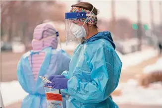  ?? Rick Bowmer / Associated Press ?? A nurse prepares a COVID-19 test outside the Salt Lake County Health Department on Dec. 20 in Salt Lake City. After three years of adjusting to life under COVID-19, Americans now face a new landscape that could limit access to health care and bring the prospect of higher costs as the national emergency declaratio­ns over the killer virus are lifted May 11.