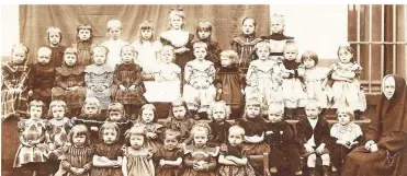  ?? FOTO: ARCHIV BRZOSA ?? So richtig glücklich sehen die Kleinen im Kindergart­en an der Martinstra­ße mit ihrer „Dienstmagd Jesu Christi“nicht aus. Das Bild entstand um 1900.