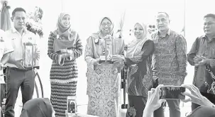  ??  ?? TERIMA KASIH: Fuziah menerima cenderamat­a daripada pengarah majlis, Zulhaidah Suboh (tiga kanan) yang juga calon Exco Wanita Pusat sambil disaksikan Nurul Ilham (dua kiri) dan ahli PKR di Sibu semalam.