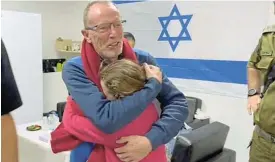  ?? /Reuters/IDF ?? Joy amid pain: Irish-Israeli girl Emily Hand, who was abducted by Hamas gunmen, embraces her father, Thomas Hand, after being released as part of a hostage-prisoner swap between Hamas and Israel on November 26.