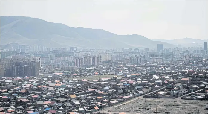  ??  ?? URBAN DRIFT: A general view of the outskirts of Ulan Bator. On the steep hills encircling Mongolia’s capital, skyscraper­s and apartments give way to ramshackle bungalows and tattered yurts.