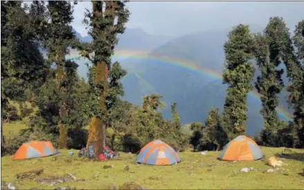  ?? CASS COLMAN — NOLS — NATIONAL OUTDOOR LEADERSHIP SCHOOL VIA AP ?? National Outdoor Leadership School students’ tents are setup while on a backpackin­g course in India as a rainbow can be seen from their tents while they explore India’s Pindari region.
