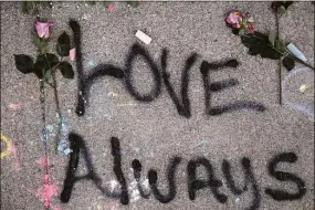  ?? Spencer Platt / Getty Images ?? Messages on the sidewalk are seen on Friday at the memorial outside Tops market in Buffalo, N.Y., for victims of the May 14 shooting. 18-year-old Payton Gendron is accused of the mass shooting that killed 10 people at the grocery store on the east side of Buffalo. The incident is being investigat­ed as a hate crime.