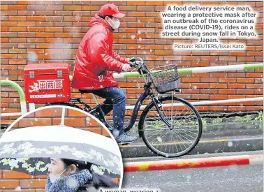  ?? Picture: REUTERS/Issei Kato ?? A food delivery service man, wearing a protective mask after an outbreak of the coronaviru­s disease (COVID-19), rides on a street during snow fall in Tokyo, Japan.