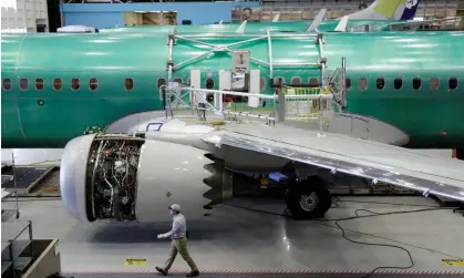  ?? ?? A worker walks past a Boeing 737 Max 9 under constructi­on at the aircraft maker’s production facility in Renton, Washington, in February 2017. Photograph: Jason Redmond/Reuters