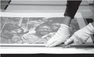  ?? PHOTOS BY KIICHIRO SATO THE ASSOCIATED PRESS ?? LEFT: Hauge prepares another print for the exhibit.