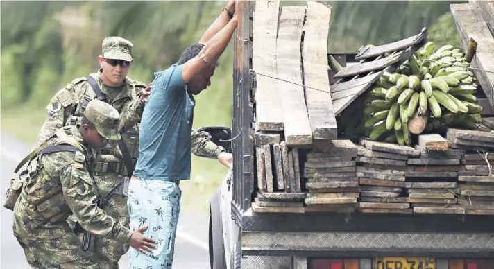  ??  ?? ► Soldados colombiano­s interrogan a un hombre en el municipio de Tumaco durante la operación de búsqueda de “Guacho”, el sábado.