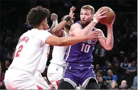  ?? FRANK FRANKLIN II / AP ?? Sacramento Kings’ Domantas Sabonis (10) protects the ball from Brooklyn Nets’ Cameron Johnson (2) and Mikal Bridges on Thursday in New York.