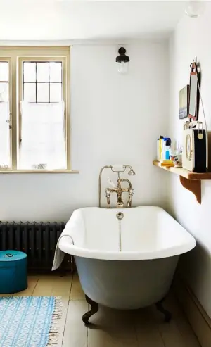  ??  ?? MAIN BEDROOM In the main bedroom, a bold burst of bright yellow lifts a neutral colour scheme and enhances the light
BATHROOM
The rolltop bath was an Ebay find