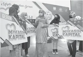  ?? — Gambar Bernama ?? BANTU USAHAWAN: Rina (tengah) beramah mesra bersama para penerima geran pada Majlis Penyerahan Geran MyKasih Kapital di sebuah hotel di Sepang, semalam.