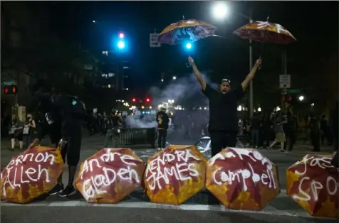  ?? Dave Killen/The Oregonian via AP ?? Umbrellas bearing the names of people killed by police are displayed on a street in downtown Portland, Ore., as demonstrat­ors gather July 10 to protest police violence.