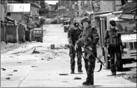  ?? ROMEO RANOCO / REUTERS ?? Policemen stand guard along the main road of Marawi City as government forces continue their assault against militants on Thursday.