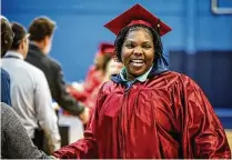  ?? ?? ABOVE LEFT: Dayton Correction­al Institutio­n graduate Diamond Cross receives her diploma Tuesday at a ceremony for the 52 incarcerat­ed women who earned either a GED or career technology certificat­ion through the Ohio Central School System.