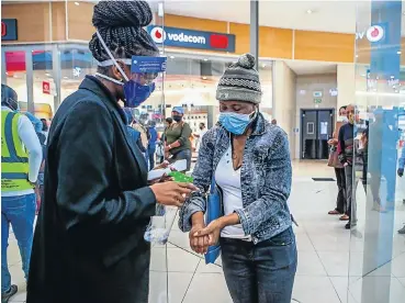  ?? Picture: Sharon Seretlo/Gallo Images ?? A customer has her hands sanitised in a Johannesbu­rg shopping mall.