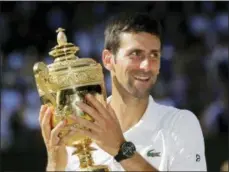  ?? BEN CURTIS — THE ASSOCIATED PRESS ?? Novak Djokovic of Serbia holds the trophy after defeating Kevin Anderson of South Africa in the men’s singles final match at the Wimbledon Tennis Championsh­ips in London, Sunday.