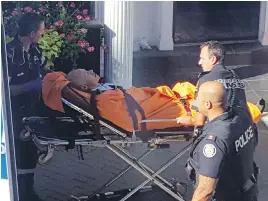  ?? PETER SCHILLING VIA THE CANADIAN PRESS ?? Paramedics take Toronto trial lawyer J. Randall Barrs to hospital after Tuesday’s shooting outside his Yorkville law office.