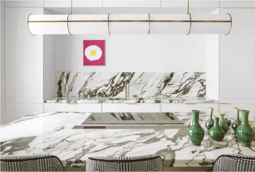  ??  ?? KITCHEN
María has adopted the trend for heavily patterned quartzite worktops, which add a pop of visual interest in an otherwise pared-back space. Bespoke pendant light, Estudio Mar’a Santos. Vases, Bingutti by Estudio Maria Santos. Try Caesarston­e for similar worktops