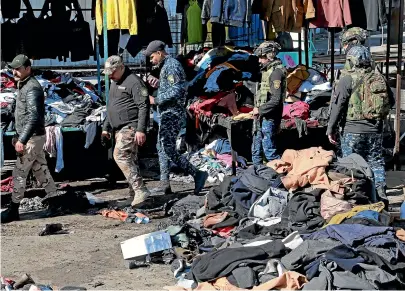  ?? AP ?? Security forces work at the site of a deadly bomb attack in Baghdad, Iraq.