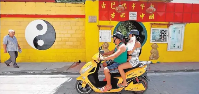  ?? // EFE ?? Una familia en moto pasa por una calle del barrio chino de La Habana