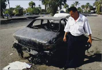  ?? KHALID MOHAMMED — THE ASSOCIATED PRESS ?? An Iraqi traffic policeman inspects a car destroyed by a Blackwater security detail in Baghdad, Iraq, in 2007.