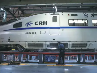  ?? LIU ZHENG / XINHUA ?? A worker checks the side of a bullet train in Nanning, Guangxi Zhuang autonomous region, on Feb 6. Chinese high-speed rail technology has gone global.