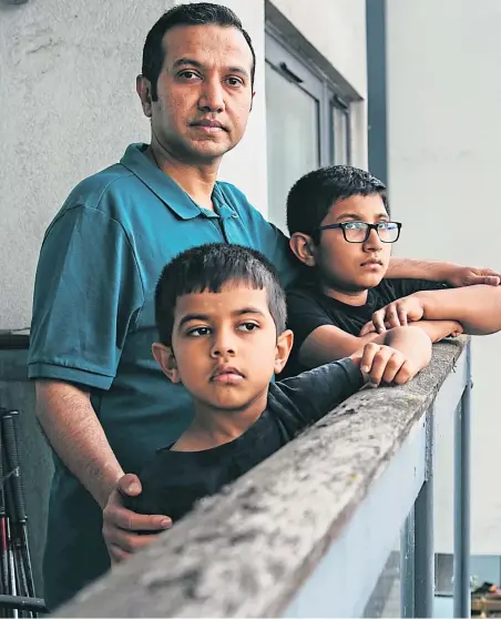  ??  ?? Abhijeet Kadwe with sons Kiann and Advay on the balcony their Finnieston home at Lancefield Quay, Glasgow